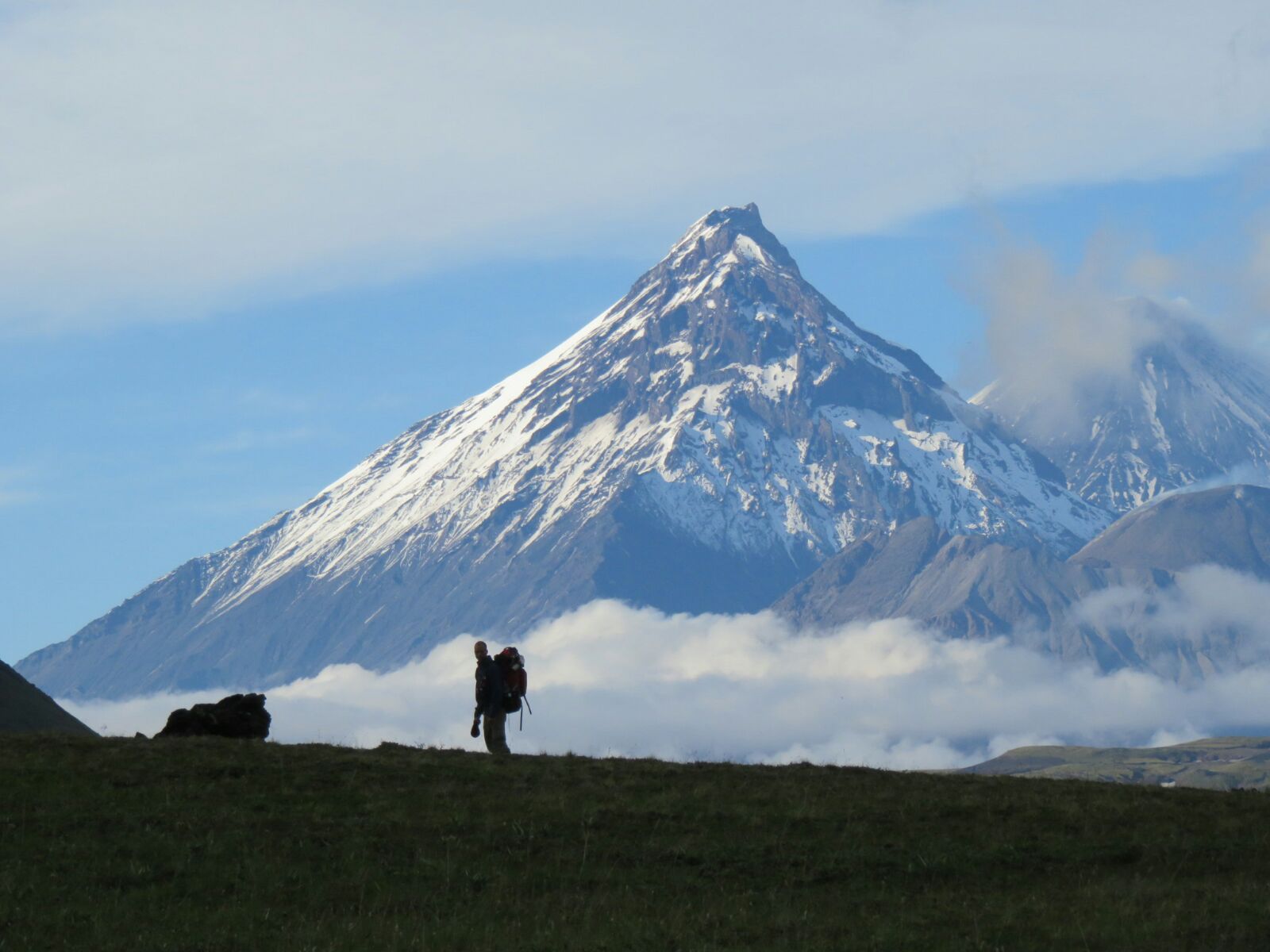 David Yinhar Backpacking with volcano behind him