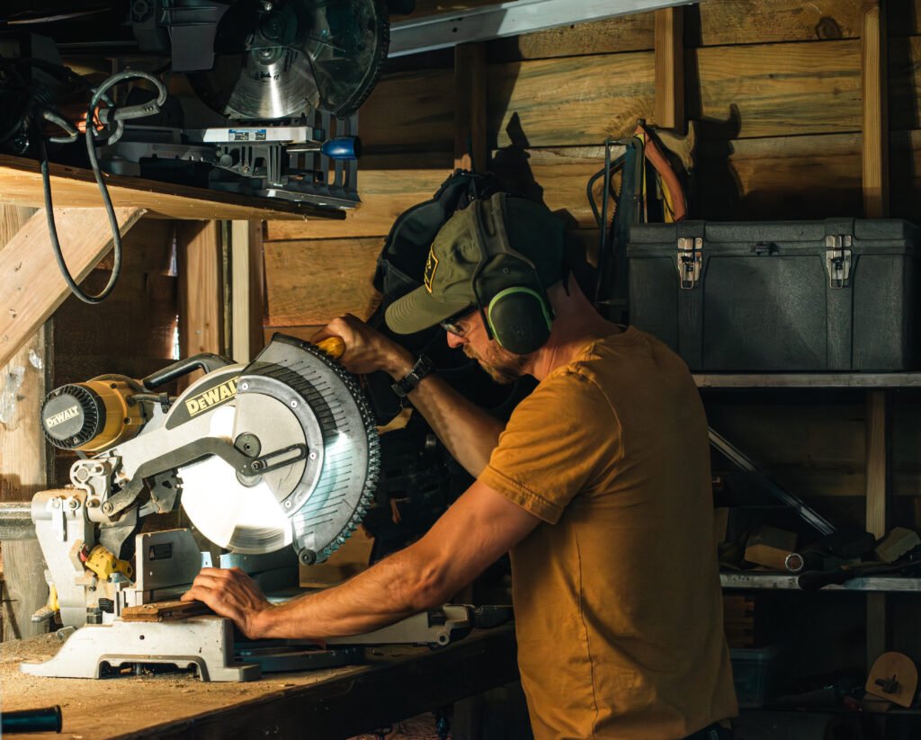David Yinhar cutting wood with a miter saw in a shop
