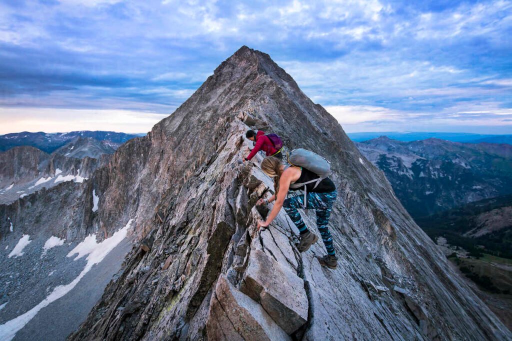 Women on peak Two women traversing a sharp peak